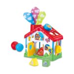 Бебешка къща Leap Frog 4 в 1, VTech: бяла къщичка с червен покрив и шарени кърпички с облачета в комина, жълта вратичка и картинки на мече и лисица, до нея червена и синя топка и фигури за сортиране.