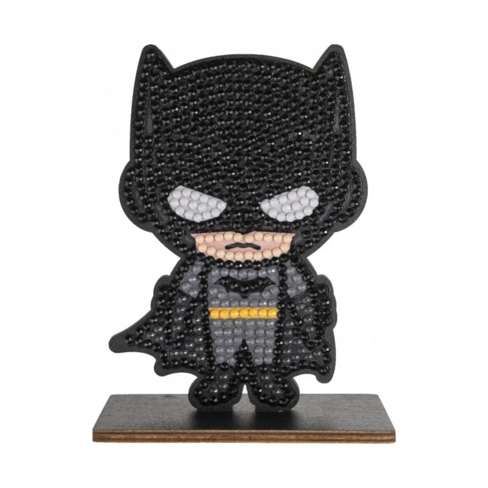 diamanten-goblen-batman-craft-buddy-1500 Диамантен гоблен Батман, Craft Buddy: черна фигурка с маска с уши, бели очи и жълт колан, покрита с лъскави кристалчета и изправена на дървена поставка.