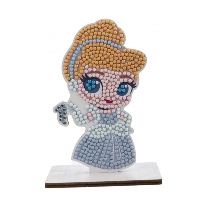 diamanten-goblen-pepelyashka-craft-buddy-1500 Диамантен гоблен Пепеляшка, Craft Buddy: фигурка с руса прическа, големи сини очи и сребристосиня рокля от кристалчета, която държи стъклена пантофка на бяла поставка.