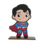 Диамантен гоблен Супермен, Craft Buddy: фигурка с голяма глава, черна коса и синьо трико с червено наметало и знак „S“ на гърдите, изцяло от кристалчета върху кафява поставка.