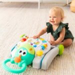 Усмихнато бебе играе с активна играчка