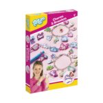 Очарователни гривни, Totum: розово-жълта кутия „Charms & Bracelets“ с верижки с висулки еднорози, дъги и сладоледи и усмихнато момиче с гривни на китката.
