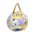 Творчески комплект куфарче Stitch Направи си сам 2 в 1, Totum: кръгла бяла кутия на дребни сини фигурки и златна шнурова дръжка, отпред бяла чаша със Стич и боички и нанизи от лилави и розови мъниста с пискюли.