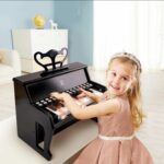 Момиче с корона свири на дървено пиано черно, Hape