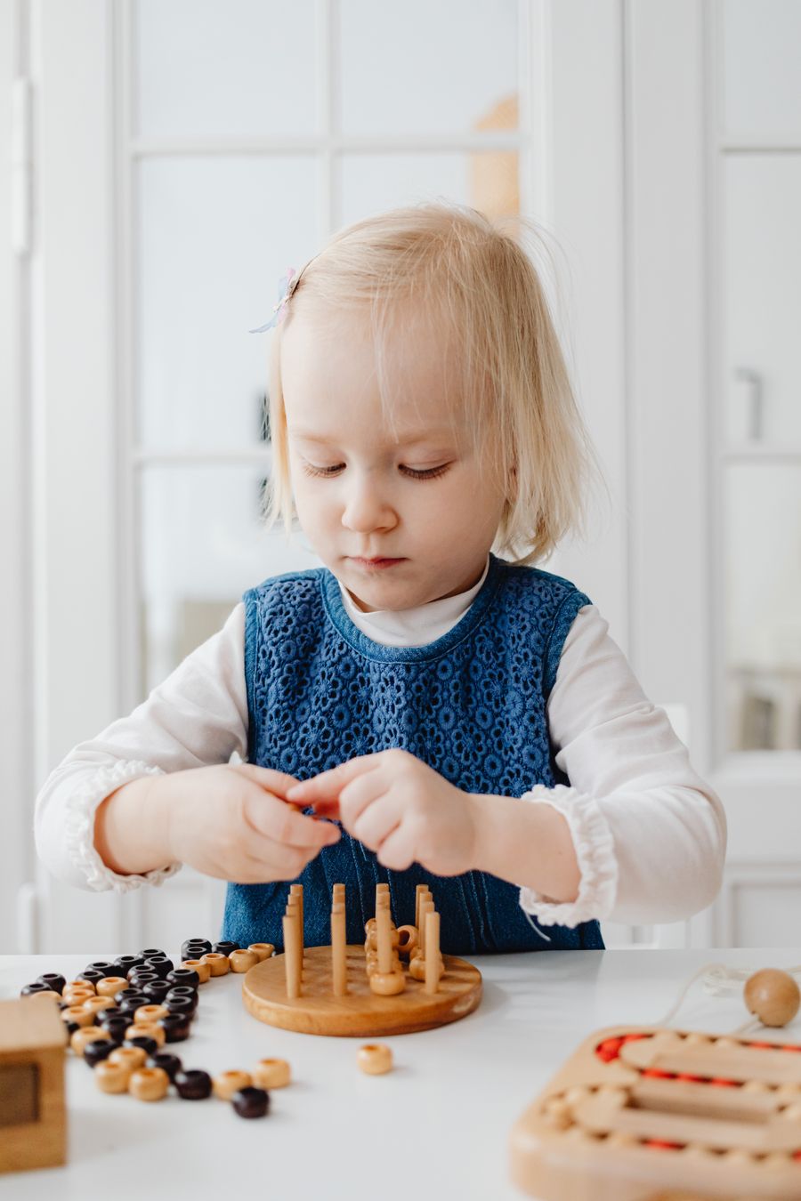 Дете играе с образователни дървени играчки