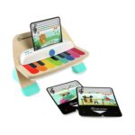 Дървеното пиано Hape Baby Einstein с тюркоазени крачета и нотни карти до него