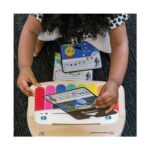 Дете слага нотна карта на пианото Hape Baby Einstein, погледнато отгоре