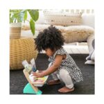 Момиченце свири на дървеното пиано Hape Baby Einstein на пода в хола