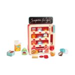 Вендинг машината Hape с черна табела Surprise for you и продукти, монети и капсули пред нея