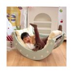 Момиченце се смее с вдигнати крачета в зеления модул Feelkids, обърнат като лодка