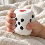 Детска ръка стиска силно белия зар и страните му хлътват.