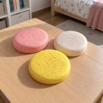 Розов, бял и жълт butter скуиши диск, оставени на дървена масичка в детска стая.