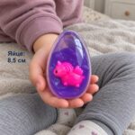 Затворено яйце с лилав слайм и еднорогче в детска шепа, с надпис Яйце: 8,5 см.