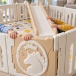 Кошара за игра Feelkids с пързалка отблизо: детски ръце на ръба на пързалката до вратичката с еднорог