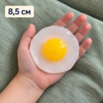 Лепкавото яйце на очи в отворена детска длан, с надпис 8,5 см.