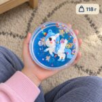 Синият putty slime със звездички и бяло-синя фигурка на еднорог в кръгла кутийка върху детска длан, с означение 118 г.