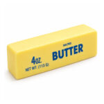 Жълтото скуиши масло, обърнато под ъгъл с надписа BUTTER отпред, на бял фон.