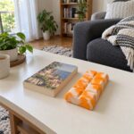 Оранжево-бял скуиши шоколад на ниска масичка в хола до книга.