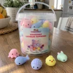 Прозрачна кофичка със скуиши и стикер Комплект Скуиши Кофичка на кухненска маса, пред нея са пет мини скуиши